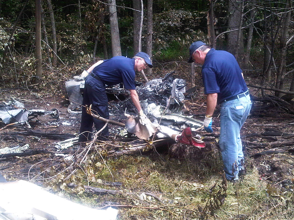 Two TSB investigators examining the wreckage from the Beechcraft BE-35