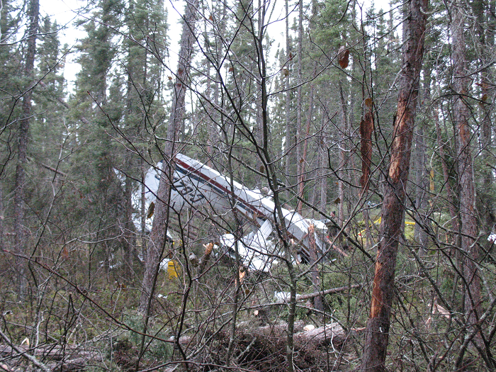 Wreckage from the Lake LA-250 aircraft in a densely wooded area