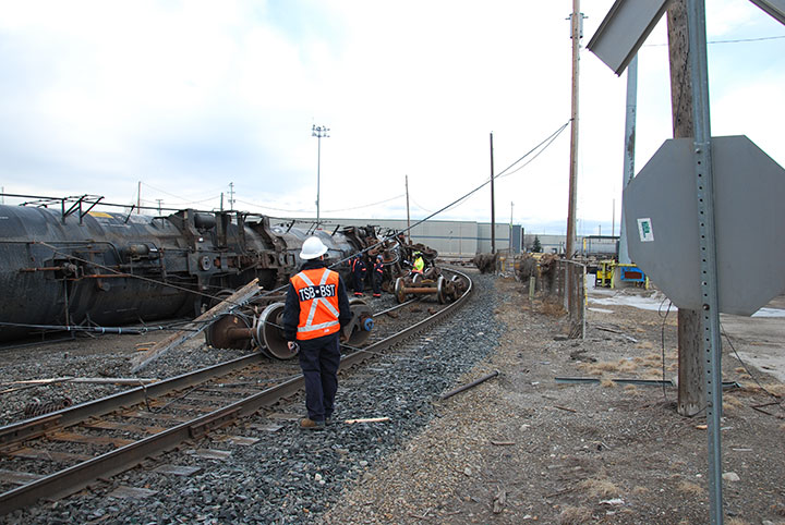 Image of TSB Investigator examining derailed cars