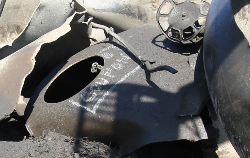 Photo of tank car WFIX 130682 showing a sheared-off head with the round hole where the coupon has been cut out using water-jet equipment