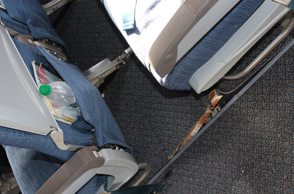 Floor damage forward of passenger seat 31D