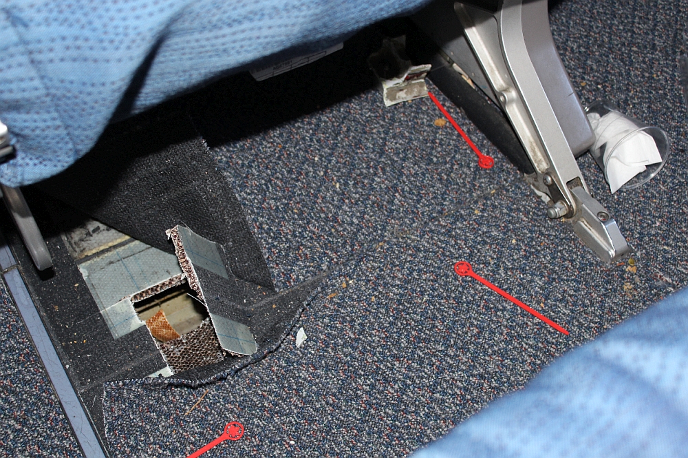 Floor damage forward of passenger seat 33D