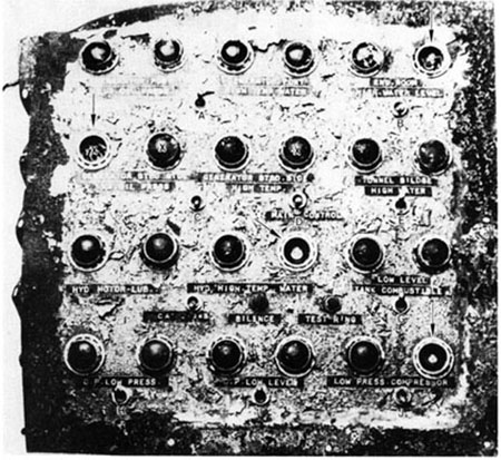 Front view of the alarm panel as recovered from sunken vessel and received by TSB laboratory. Switches are indicated by letters A-J. Arrows indicate missing lamp caps. The "X"indicates the sockets without lamps.