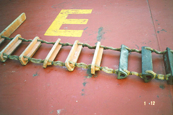 Lower section of pilot ladder with three bottom steps of hard rubber of comparable strenght of hardwood. Note steps at various angles due to slack crimping. The lowest batten is at the ninth step instead of fifth. 