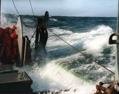 A wave breaks over the bulwarks and fills the deck, showing the important ance of watertight deck integrity