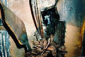 Damaged lead locomotive undercarriage with hole in fuel tank and severed electrical cables