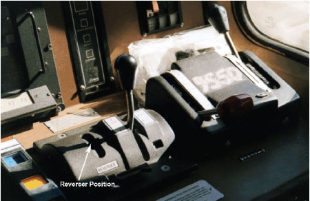Photo of locomotive desktop control stand, reverser handle receptacle indicated with arrow