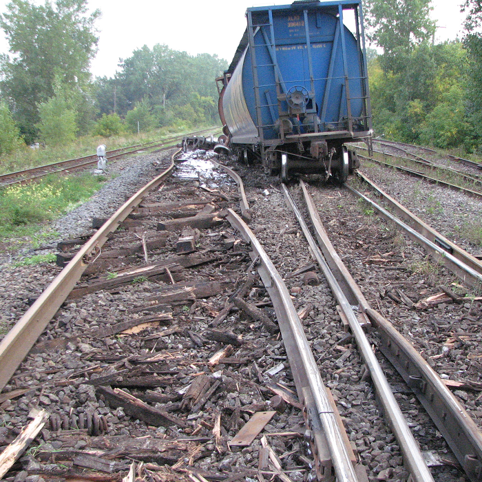 A derailed car next to the damaged track