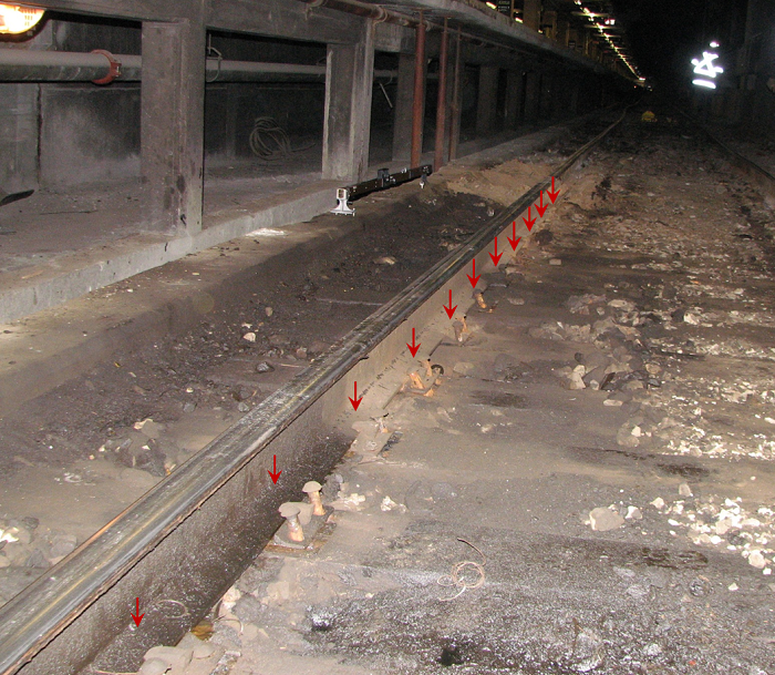 Photo of the south rail with arrows indicating the locations of 10-inch tie plates with round spikes