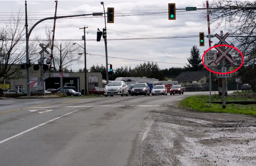 Partially obscured grade crossing warning system at crossing for approaching eastbound traffic