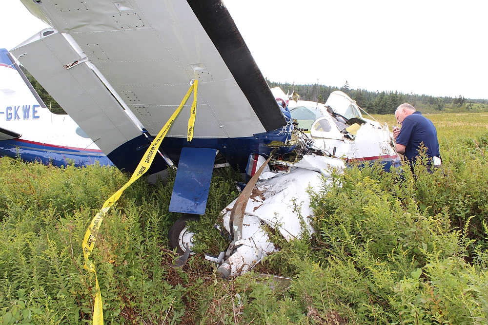 Photo d'un enquêteur examinant l'épave d'un avion sur l'île Grand Manan (Nouveau Brunswick)