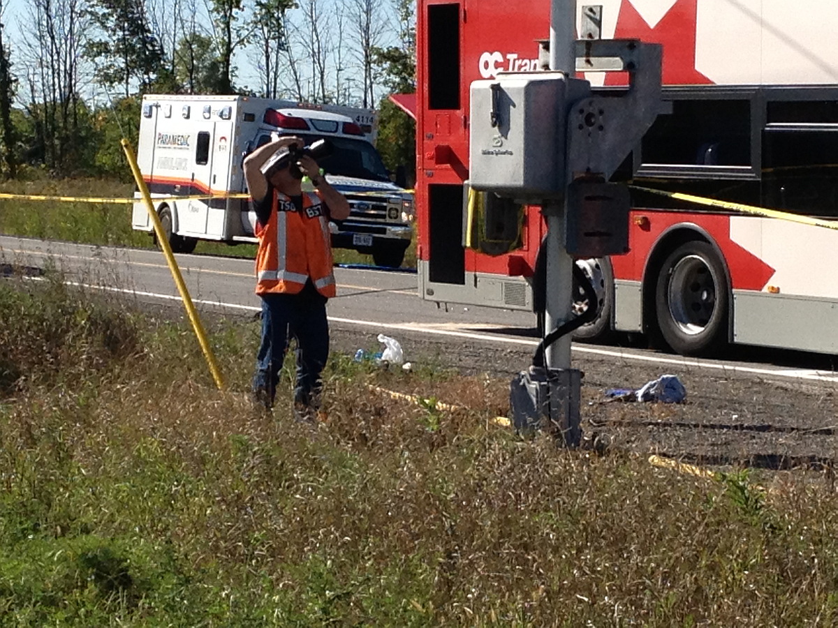 TSB investigator photographing a signal post at the scene of the accident