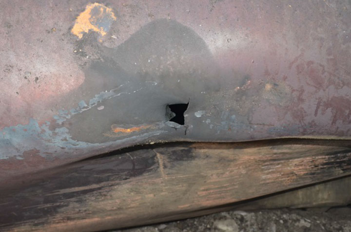 Image of Tank car ACFX 79709, dent and small shell puncture, as decribed in text