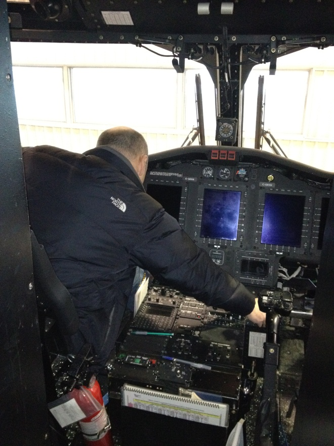 Photo of S-92A pilot reaching for landing gear handle