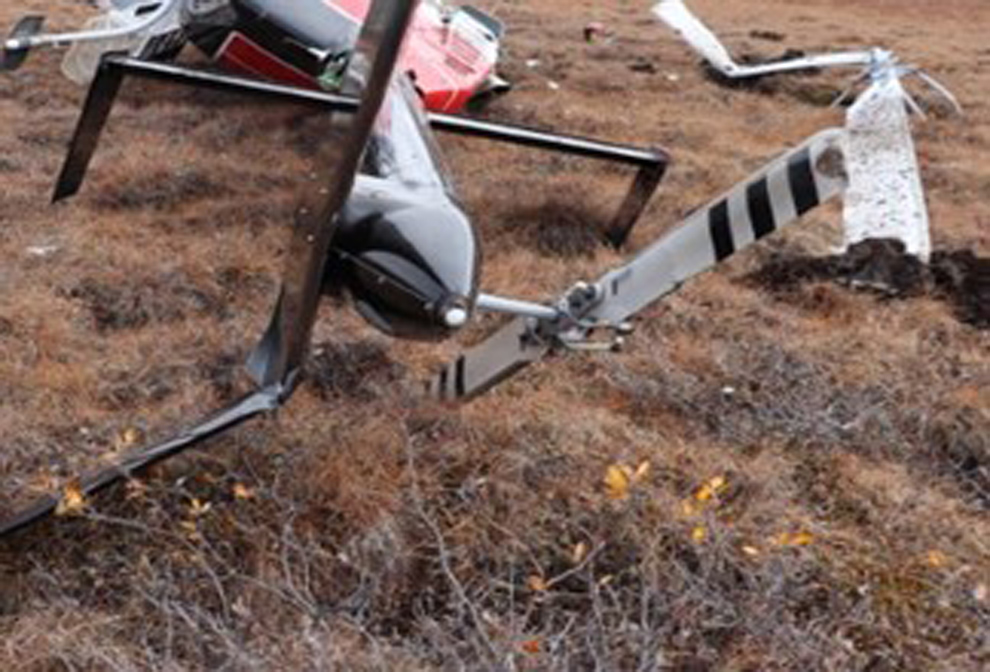 Photo of the wreckage showing the helicopter on its right side, the main rotor and the core boxes (Source: Royal Canadian Mounted Police)
