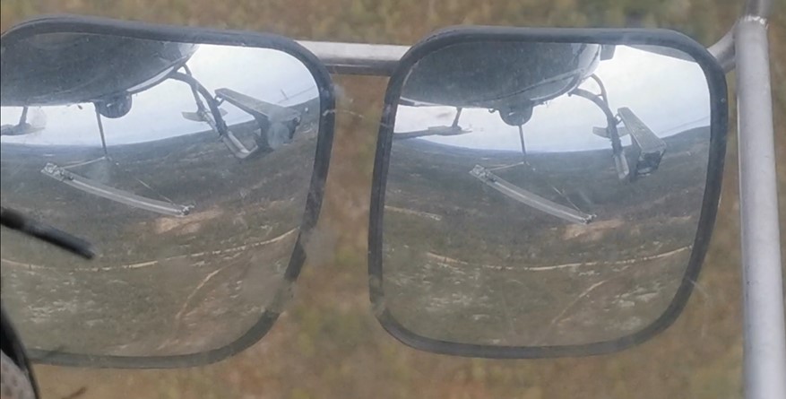 Images reflected in the helicopter’s mirrors, showing the position of the platform while being carried horizontally, without a sling, during the test flight (Source: screen shot of a video filmed by the occurrence pilot during the test flight)