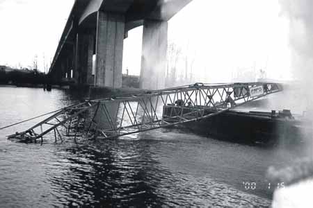 The crane moved off the barge's deck and sank under the bridge with its boom, bent during the striking, extending above the surface.
