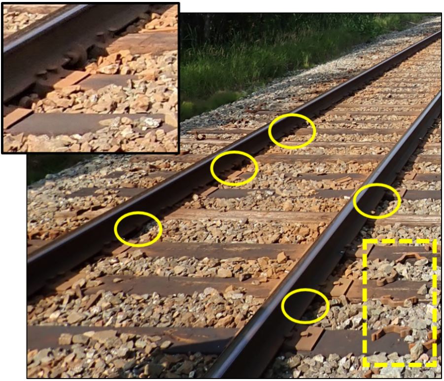 Picture of the track west of the derailment, showing anchors that had shifted away from ties (circled) and new anchors on the ground (rectangular outline), with inset showing enlarged view of shifted anchors (Source: TSB)