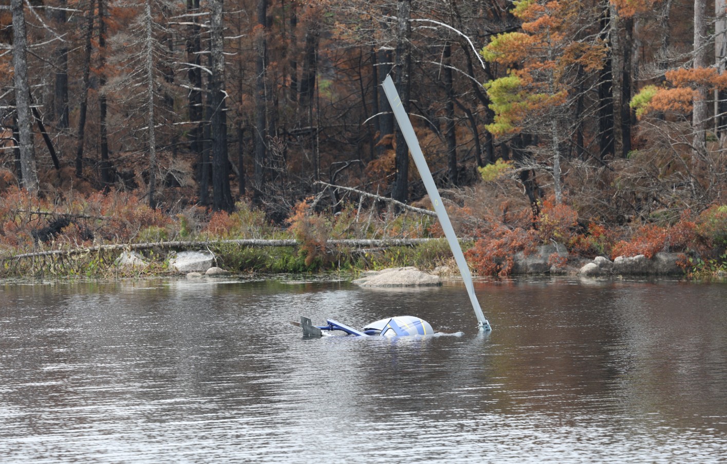 Figure 1. The occurrence helicopter in Fivefinger Lake, Nova Scotia, partially submerged, with one main rotor blade extending above the water surface (Source: Professional photographer from the Nova Scotia Department of Natural Resources and Renewables)